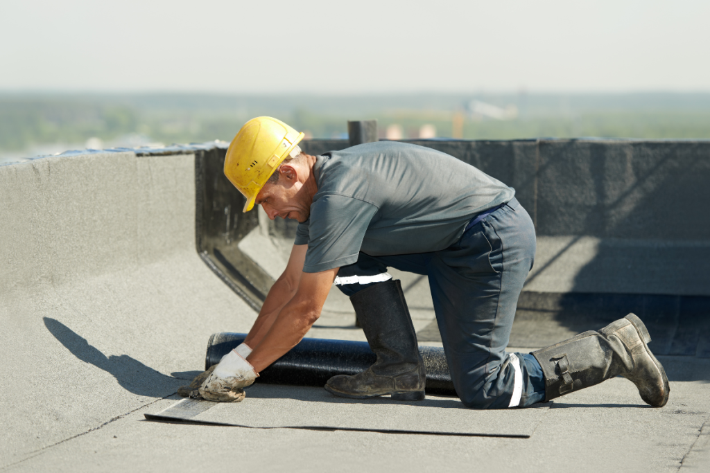 A worker in a hard hat and boots performing commercial roofing services for Mr. Max Roofing.